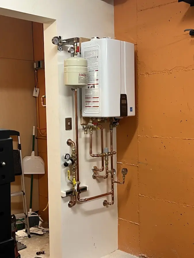 Plumbing technician inspecting water heater connections in Abingdon
